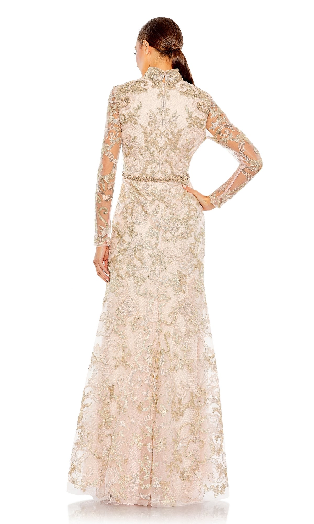 A woman stands with her back to the camera, modeling the Mac Duggal 11165 Long Sleeve Lace Formal Gown in light pink with silver embroidery, set against a white background.